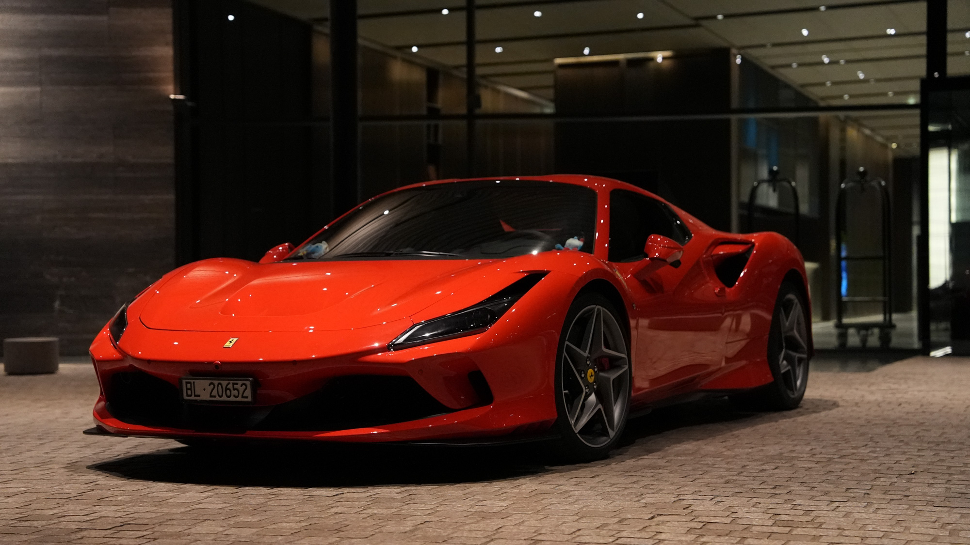 Ferrari F8 Tributo — front 3/4, hotel entrance