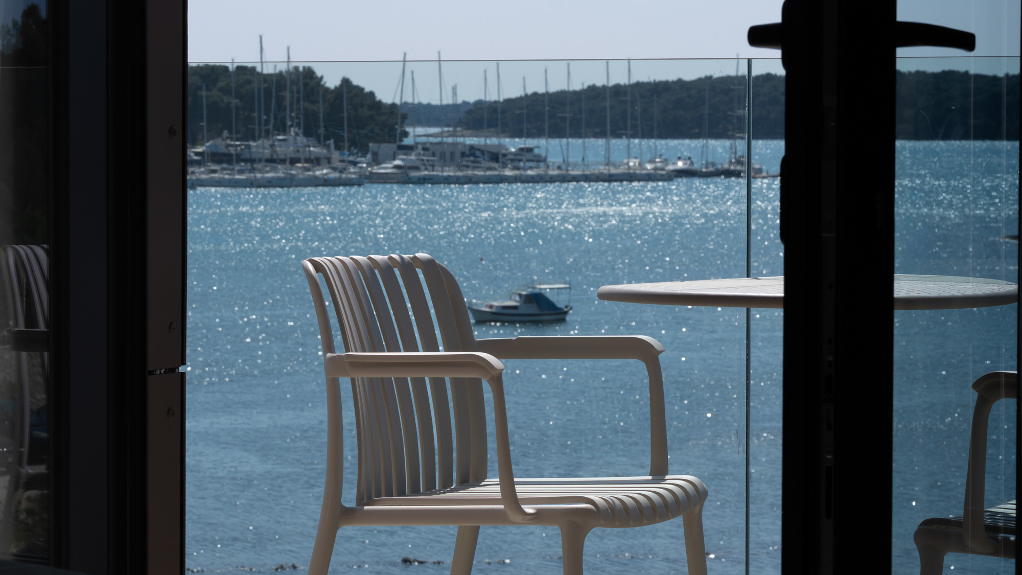 Terrace chair framed through doorway with marina view