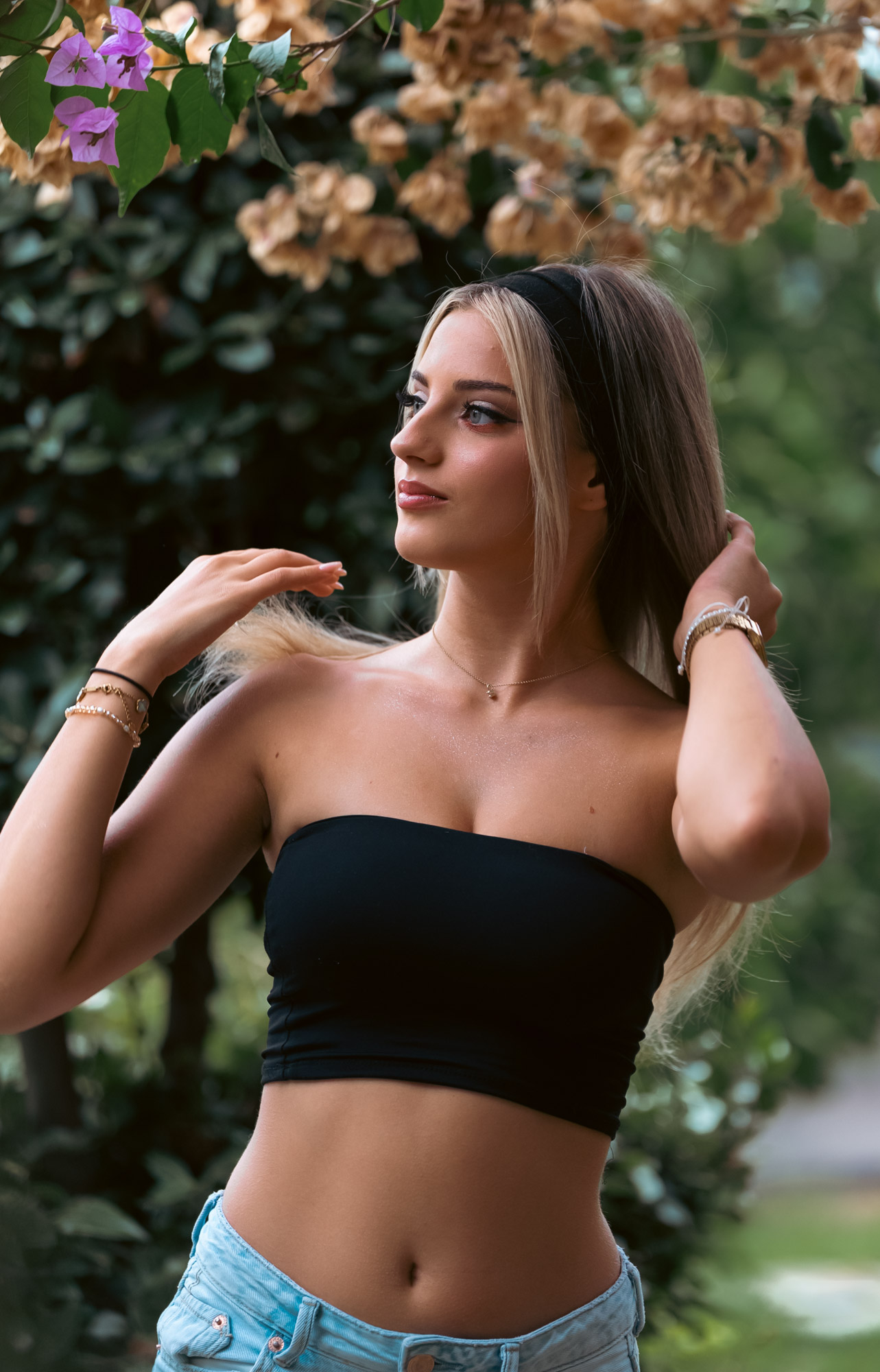 Hands lifted into the hair, turned away from camera