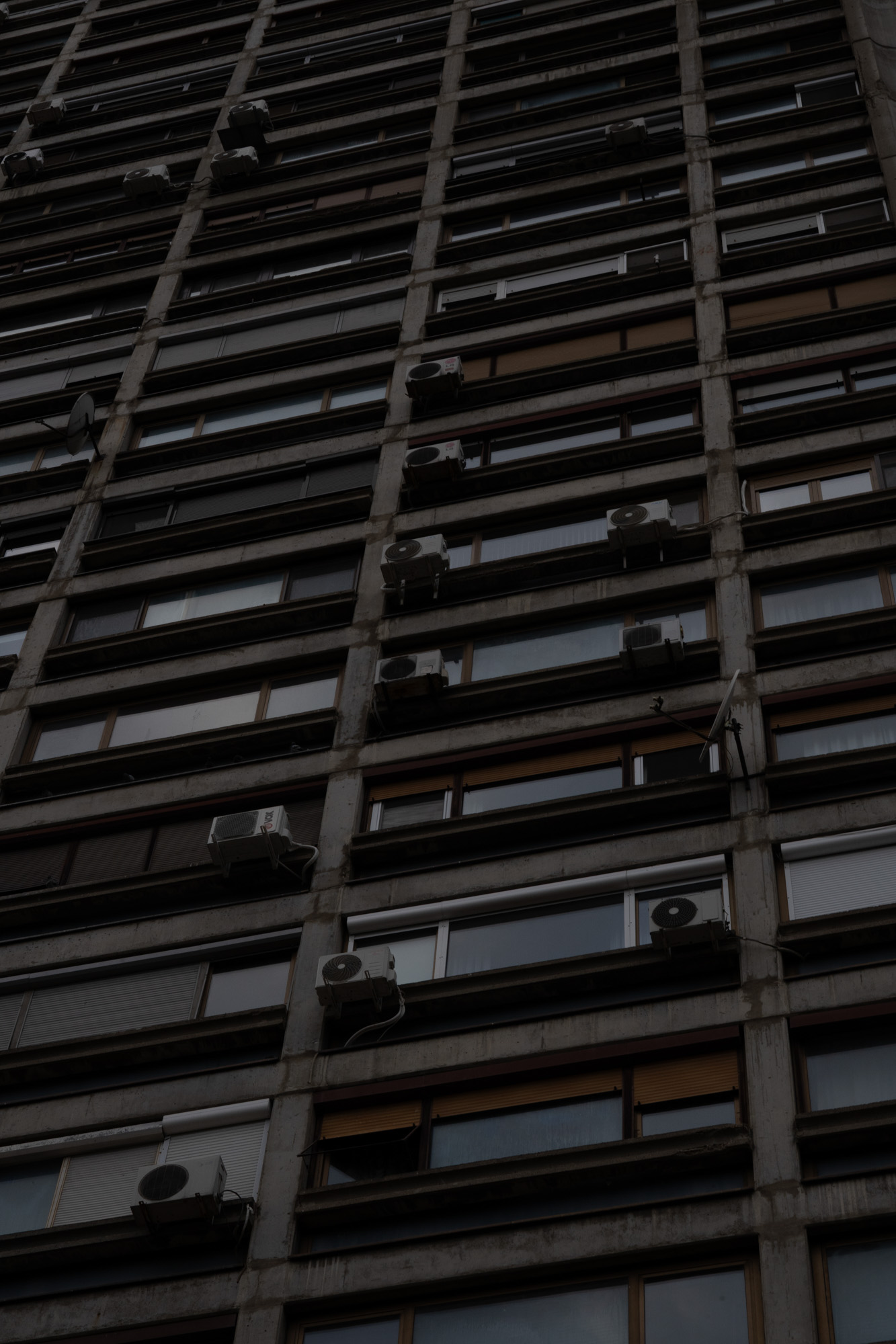 Belgrade apartment block from below — AC units stacked along the facade