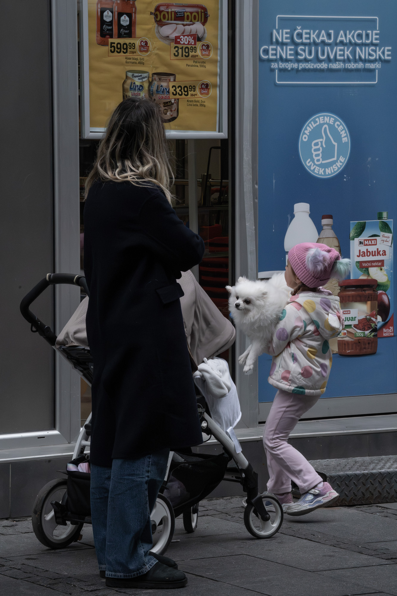 Mother, child and dog outside a Belgrade supermarket